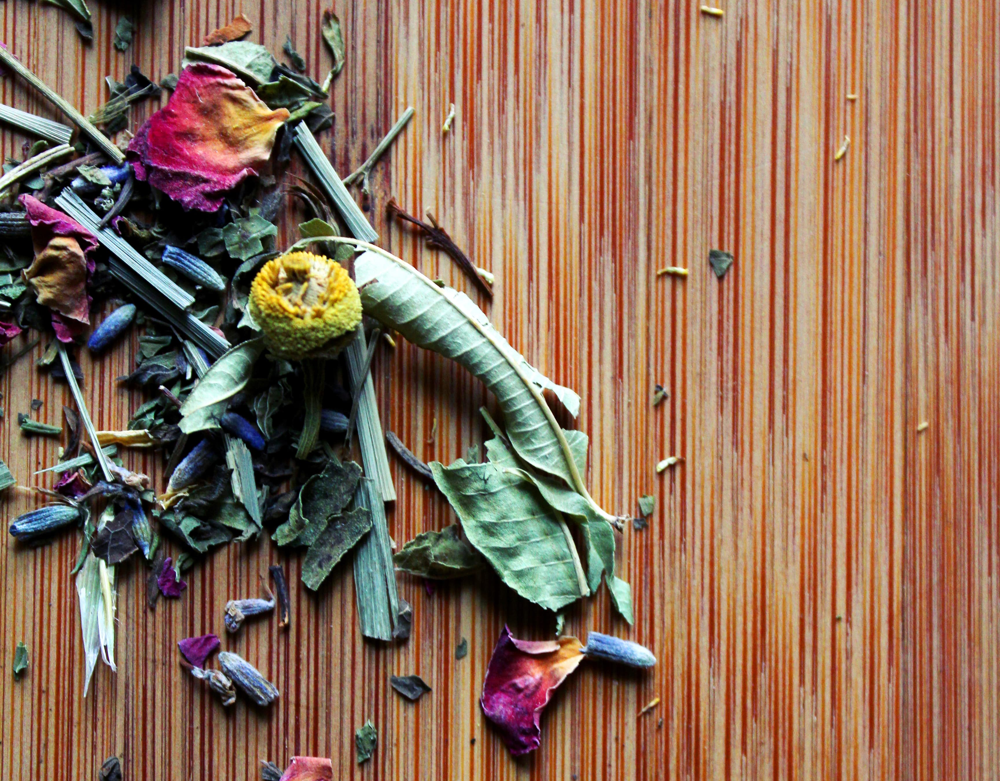 Decorative cover image for mobile webpage. Image is of a wooden cutting board with colorful dried herbs on left side